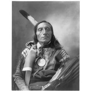 Stands and Looks Back,c1900,holding wing of large bird,Indian,feather 