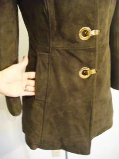   with an olive hue the coat has brass grommet and clasp closures faux